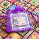 Fairytale book needle minder in a purple gift bag containing a card.
