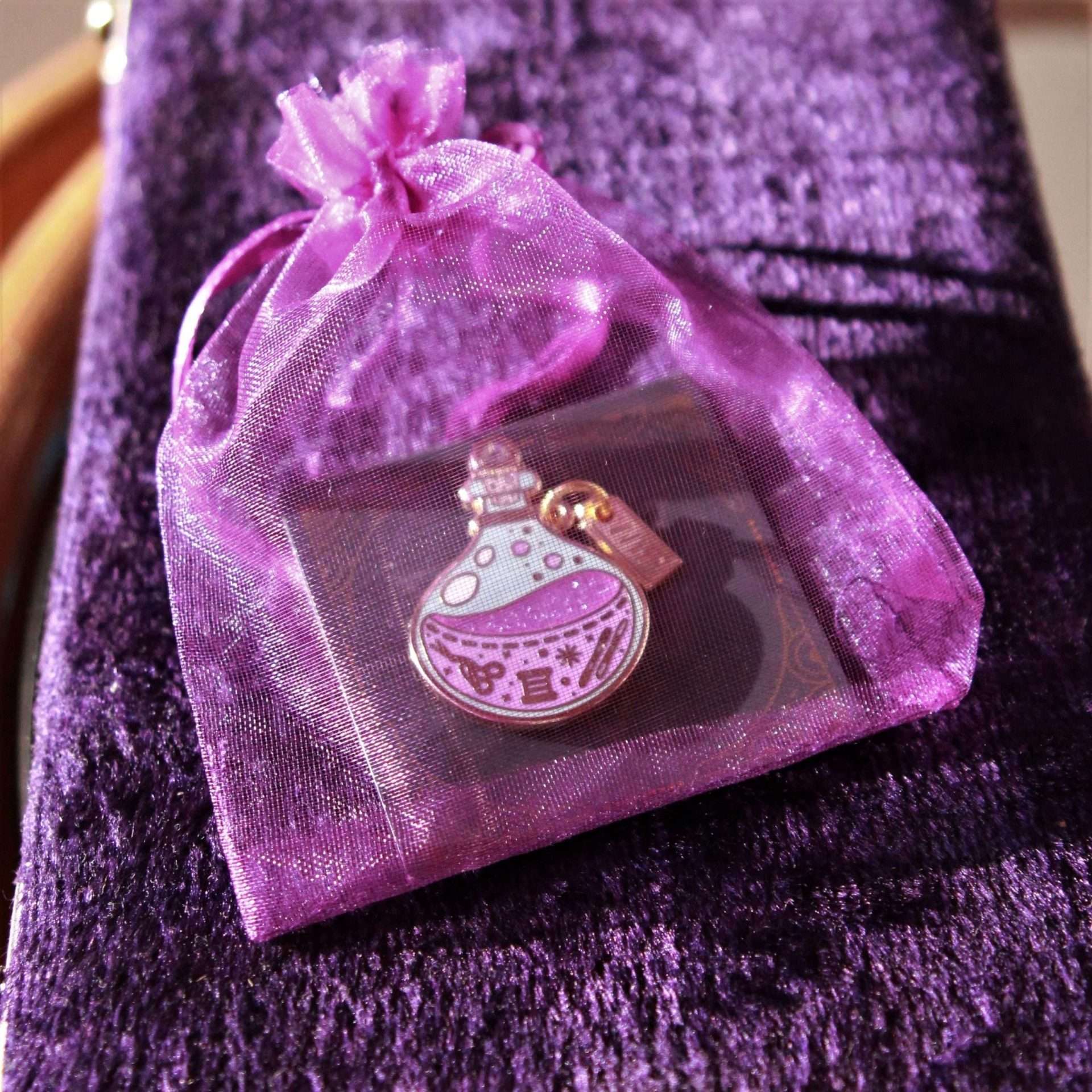 Potion bottle needle minder on backing card in prule organza gift bag.