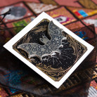 Silver and black bat shaped needle minder on a backing card and resting on a black organza gift bag.