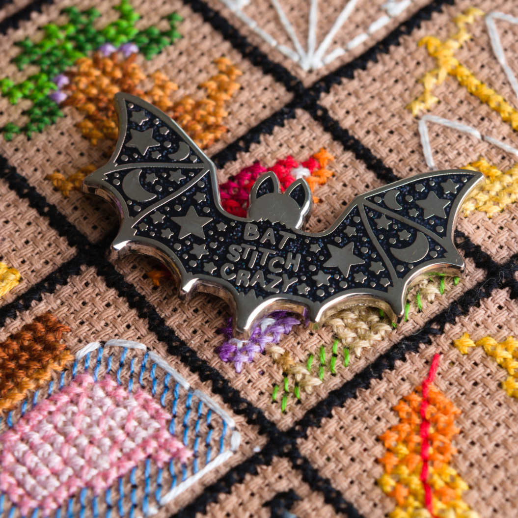 Halloween-themed cross-stitch pattern with a bat needle minder sitting on top.